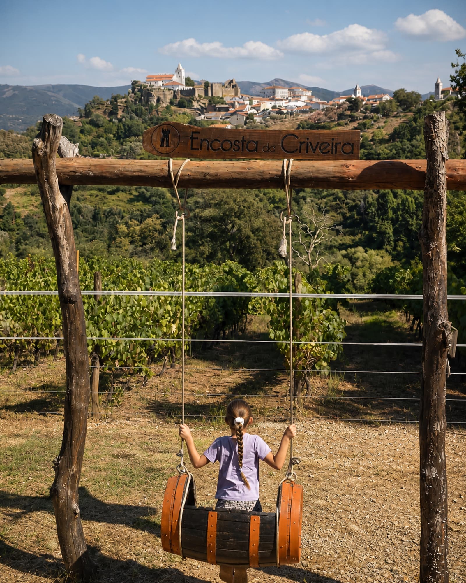 A child on the Encosta da Criveira swing looking towards Penela Castle