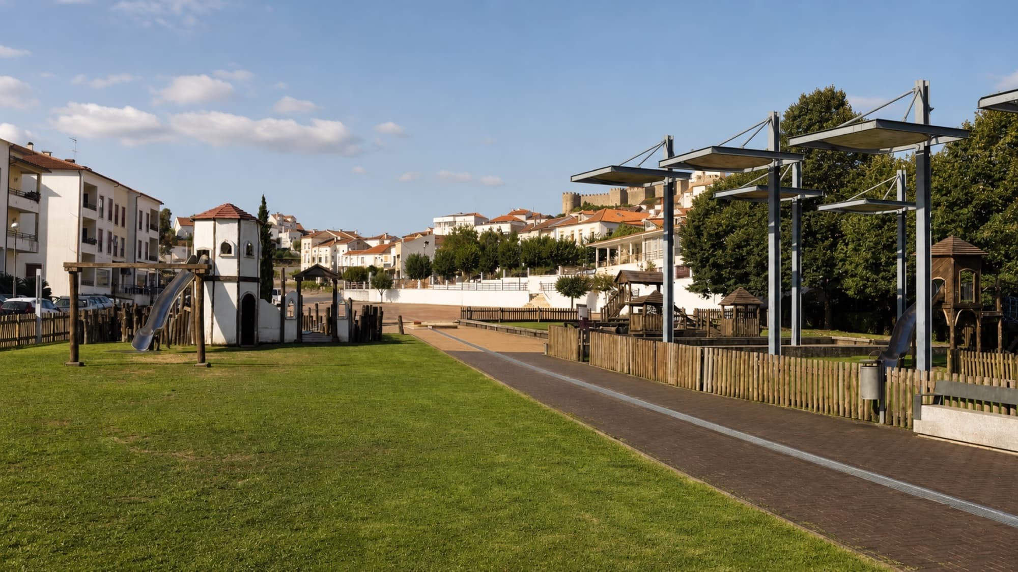 Wide view across the lawns and Roman-inspired play structures at Parque das Águas Romanas