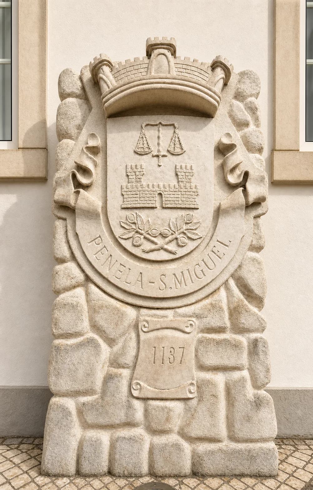 Stone civic emblem in Penela showing a castle, scales, olive branches and the date 1137